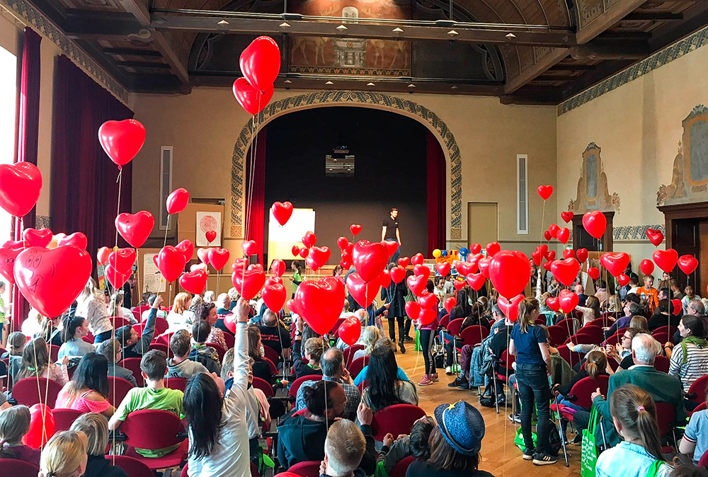 Kinder und Eltern mit Luftballon-Herzen beim Forum in Cottbus