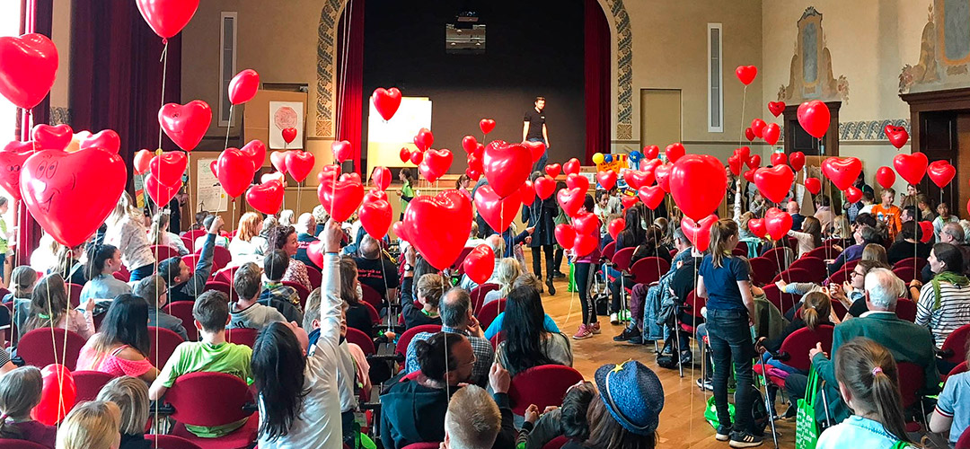 Bild: Kinder und Eltern mit Luftballon-Herzen beim Forum in Cottbus