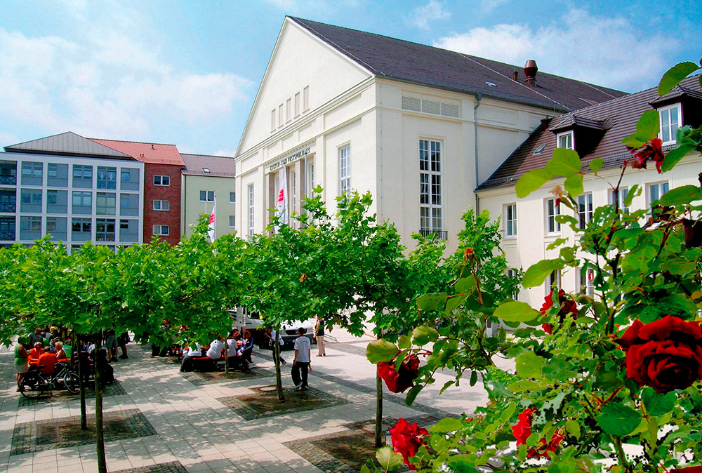 Ansicht des Kultur- und Festspielhauses und Vorplatzes mit Bäumen und Rosen in Perleberg und Wittenberge 