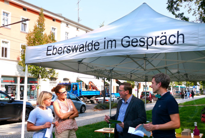 Mitarbeiter der Stadt Eberswalde im Gepräch mit zwei interessierten Passantinnen