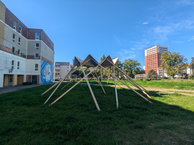 Holzkonstruktion in Form eines Pavillions auf einer Wiese