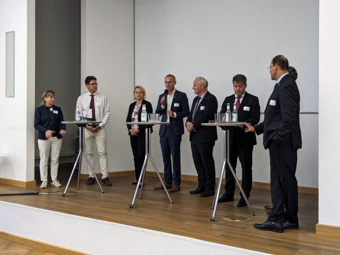 Gäste der Vernstaltung unterhalten sich im Foyer