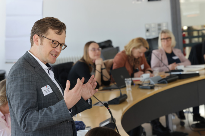 Der Bürgermeister spricht, Menschen sind im Hintergrund zu sehen